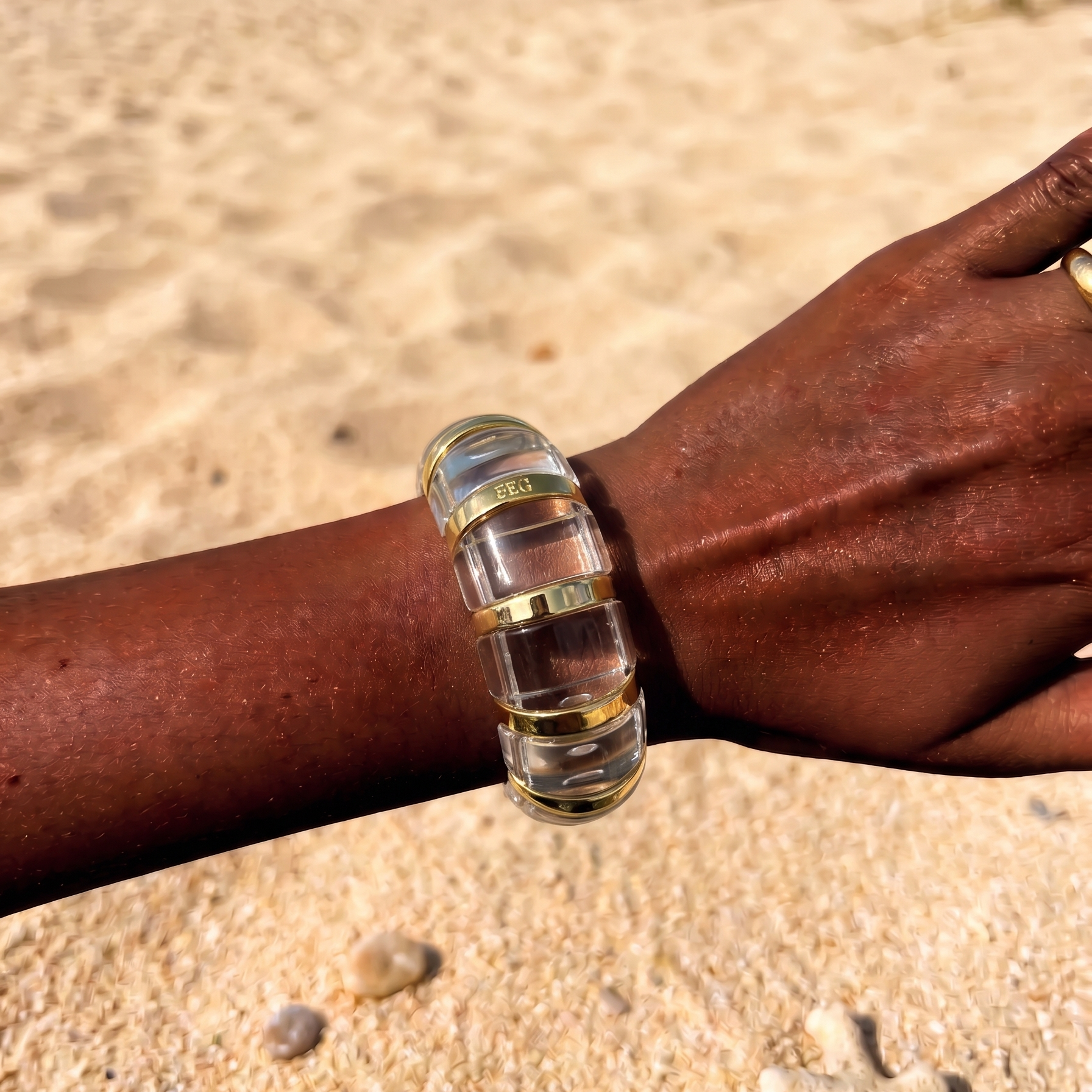 Femme portant le Bracelet June Cristal en résine transparente aux finitions dorées, au style minimaliste et lumineux.
