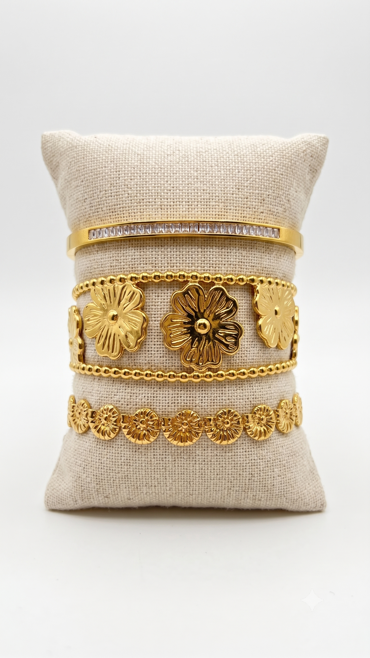 Composition Gold avec trois bracelets et un jonc dorés en acier inoxydable.