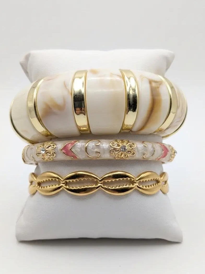 Composition Crème composée de bracelets dorés et crème en acier inoxydable, élégants, résistants à l’eau et hypoallergéniques.