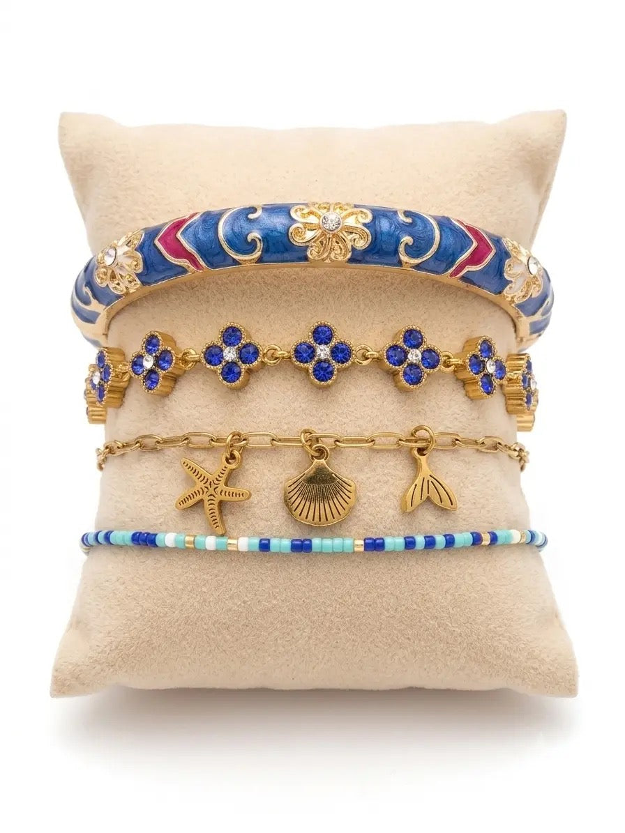 Composition Océan composée de bracelets bleus et dorés en acier inoxydable avec détails marins, élégants, résistants à l’eau et hypoallergéniques.